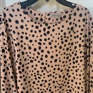 cute, flowly top that is a light pink with black polka dots.
